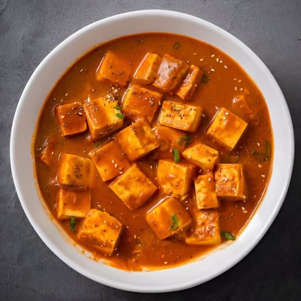Saffron Restaurant's paneer butter masala, a rich Indian curry with paneer cubes in a creamy orange sauce.